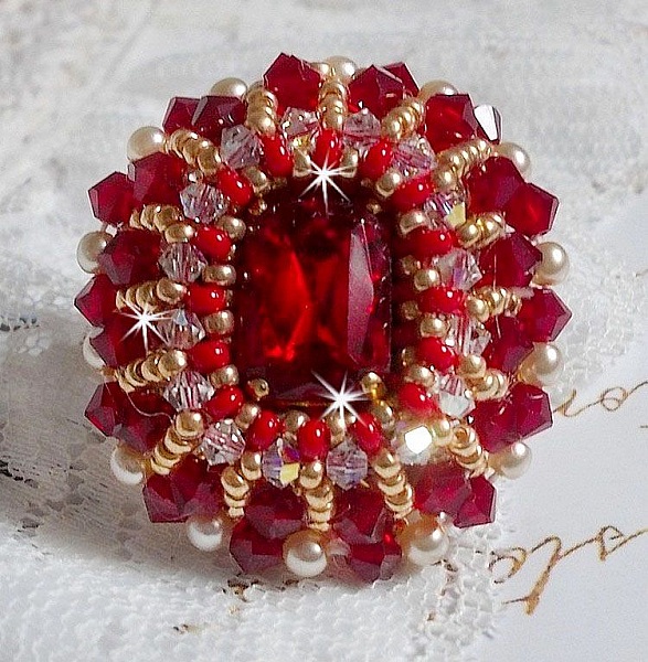 Bague Rubis brod&eacute;e avec un cabochon rectangulaire Ruby, orn&eacute;e de chatons mont&eacute;s en Cristal avec des perles rondes nacr&eacute;es en verre Ivoire, rocailles Dor&eacute;es, des toupies Cristal AB et Burgundy.