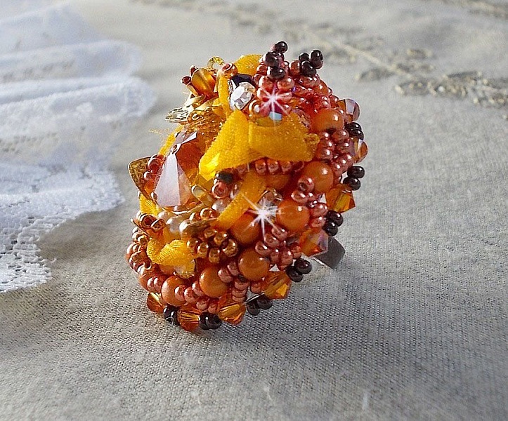 Bague Les R&ecirc;ves d'Acapulco brod&eacute;e avec un cabochon octogonale serti &agrave; laquelle s'ajoute perles rondes nacr&eacute;es, ruban organza, toupies et rocailles sur bague en laiton Bronze pour un style ethnique