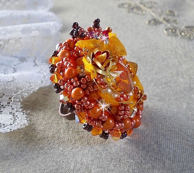 Bague Les R&ecirc;ves d'Acapulco brod&eacute;e avec un cabochon octogonale serti &agrave; laquelle s'ajoute perles rondes nacr&eacute;es, ruban organza, toupies et rocailles sur bague en laiton Bronze pour un style ethnique