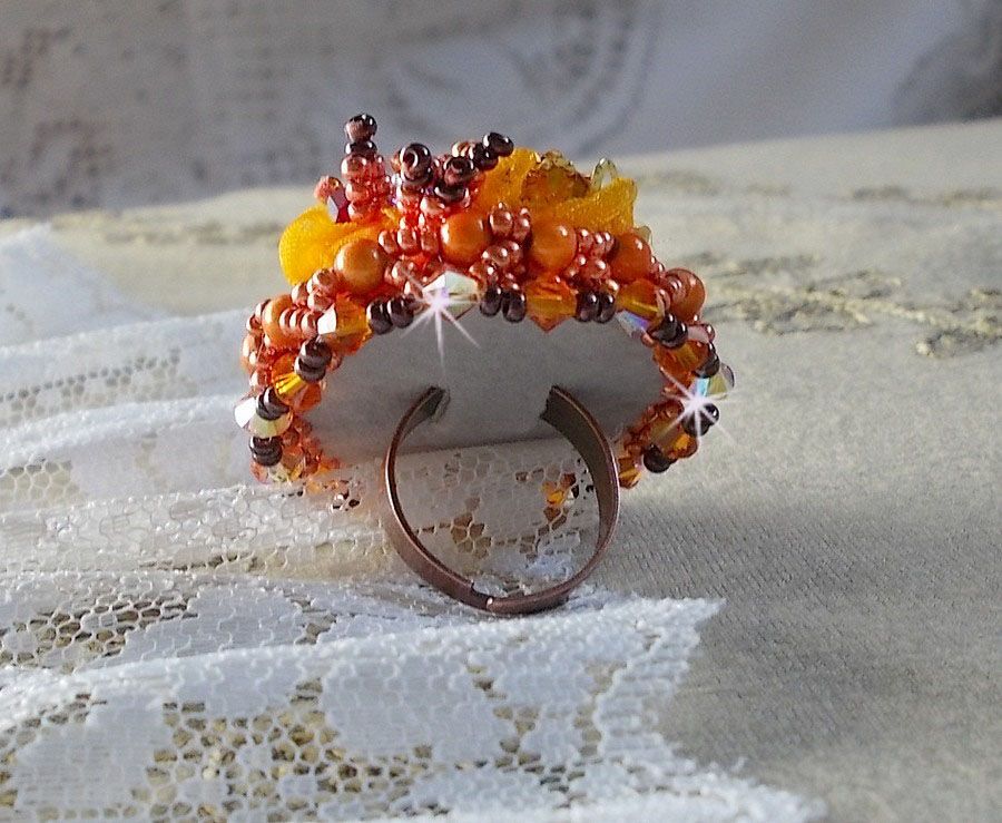 Bague Les R&ecirc;ves d'Acapulco brod&eacute;e avec un cabochon octogonale serti &agrave; laquelle s'ajoute perles rondes nacr&eacute;es, ruban organza, toupies et rocailles sur bague en laiton Bronze pour un style ethnique