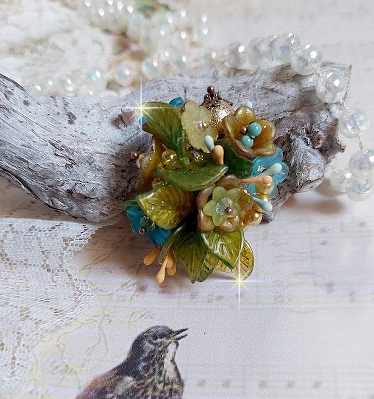 Bague C&eacute;zanne mont&eacute;e avec des petites fleurs lucites peintes &agrave; la main &agrave; laquelle s&rsquo;ajoute des feuilles, cristaux, perles, &eacute;tamines, grosses rocailles, perles nacr&eacute;es et m&eacute;tal sur une bague en Laiton