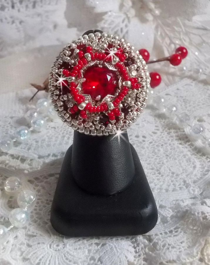 Bague Drigon Red brod&eacute;e avec un cabochon carr&eacute; Rouge sur une estampe Argent&eacute;e. Orn&eacute;e de chatons en Cristal puis model&eacute;e avec des rocailles et perles. Le tout est mont&eacute; sur une bague r&eacute;glable argent&eacute;e 