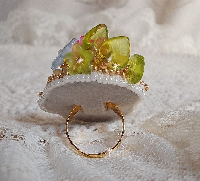 Bague Envol&eacute;e Fleurie brod&eacute;e avec un cabochon ovale Olivine en r&eacute;sine, orn&eacute;e de perles rondes nacr&eacute;es, des rocailles, fleurs Lucites, mini gouttes, chaton en Cristal et perles rondes aplaties.