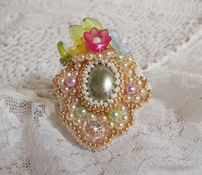 Bague Envol&eacute;e Fleurie brod&eacute;e avec un cabochon ovale Olivine en r&eacute;sine, orn&eacute;e de perles rondes nacr&eacute;es, des rocailles, fleurs Lucites, mini gouttes, chaton en Cristal et perles rondes aplaties.