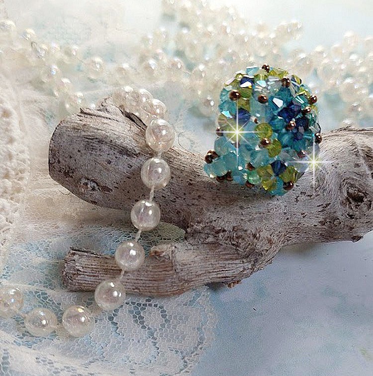 Bague Esp&eacute;rance mont&eacute;e avec toupies Aquamarine AB, Blue Zircon, Capri Blue, Olivine AB, Cristal avec des facettes entrelac&eacute;es avec des rocailles. Elle s&rsquo;adaptera parfaitement &agrave; votre doigt