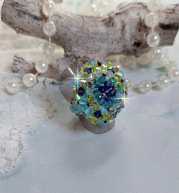 Bague Esp&eacute;rance mont&eacute;e avec toupies Aquamarine AB, Blue Zircon, Capri Blue, Olivine AB, Cristal avec des facettes entrelac&eacute;es avec des rocailles. Elle s&rsquo;adaptera parfaitement &agrave; votre doigt