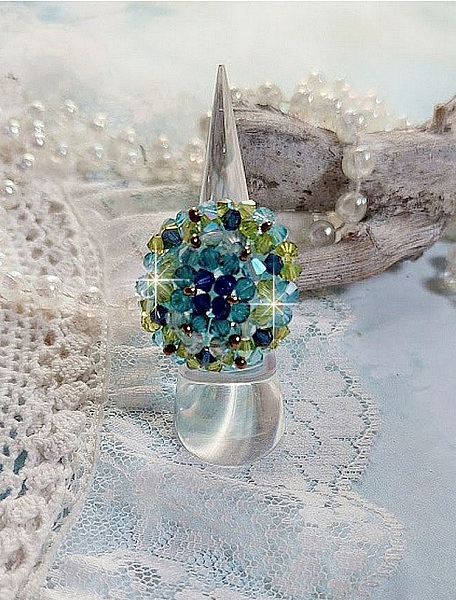 Bague Esp&eacute;rance mont&eacute;e avec toupies Aquamarine AB, Blue Zircon, Capri Blue, Olivine AB, Cristal avec des facettes entrelac&eacute;es avec des rocailles. Elle s&rsquo;adaptera parfaitement &agrave; votre doigt