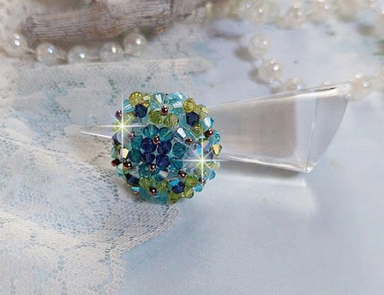 Bague Esp&eacute;rance mont&eacute;e avec toupies Aquamarine AB, Blue Zircon, Capri Blue, Olivine AB, Cristal avec des facettes entrelac&eacute;es avec des rocailles. Elle s&rsquo;adaptera parfaitement &agrave; votre doigt