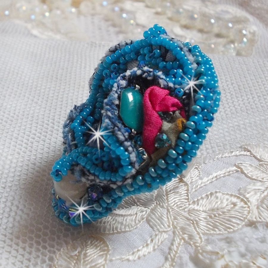 Bague Far West tout en jean brod&eacute;e avec des pierres de Gemme : Le Sodalite et le Jade Jaune &agrave; laquelle s'ajoute un tissu en Jean, un tissu mouchet&eacute; de fleurs avec des chatons en Cristal et des toupies