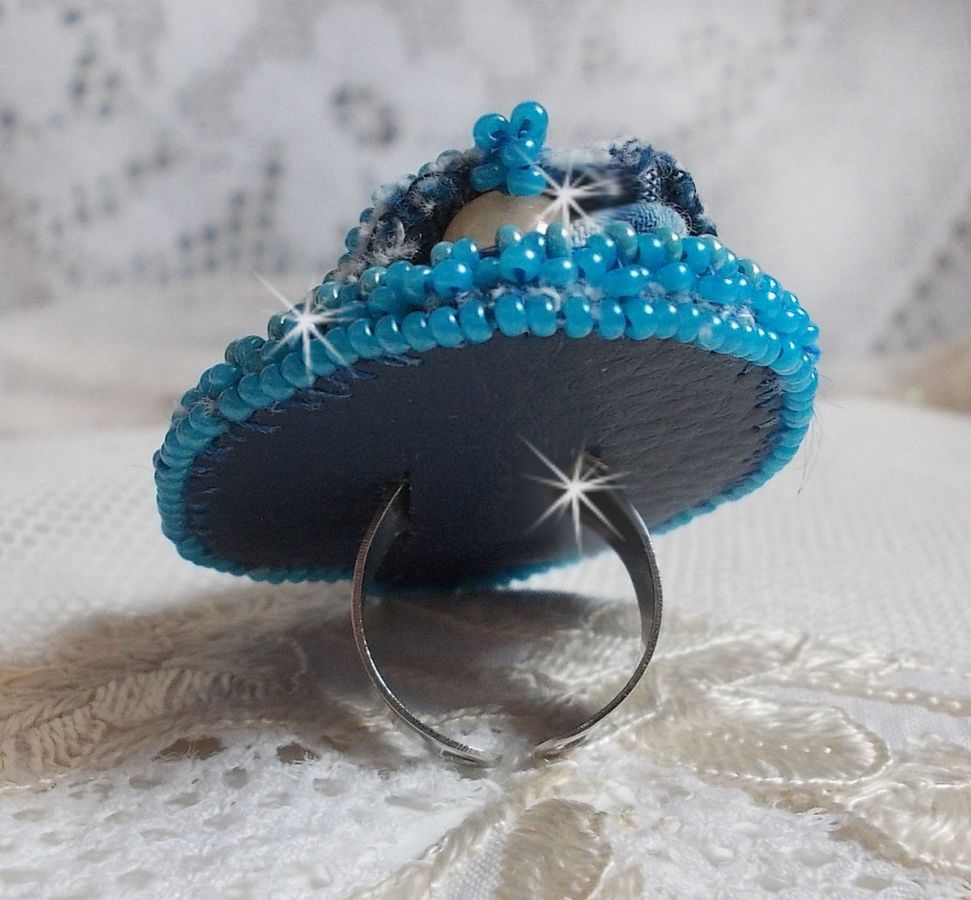 Bague Far West tout en jean brod&eacute;e avec des pierres de Gemme : Le Sodalite et le Jade Jaune &agrave; laquelle s'ajoute un tissu en Jean, un tissu mouchet&eacute; de fleurs avec des chatons en Cristal et des toupies
