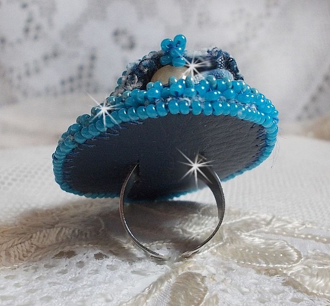 Bague Far West tout en jean brod&eacute;e avec des pierres de Gemme : Le Sodalite et le Jade Jaune &agrave; laquelle s'ajoute un tissu en Jean, un tissu mouchet&eacute; de fleurs avec des chatons en Cristal et des toupies