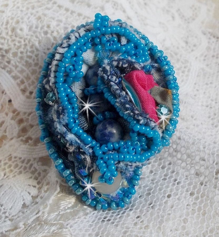 Bague Far West tout en jean brod&eacute;e avec des pierres de Gemme : Le Sodalite et le Jade Jaune &agrave; laquelle s'ajoute un tissu en Jean, un tissu mouchet&eacute; de fleurs avec des chatons en Cristal et des toupies