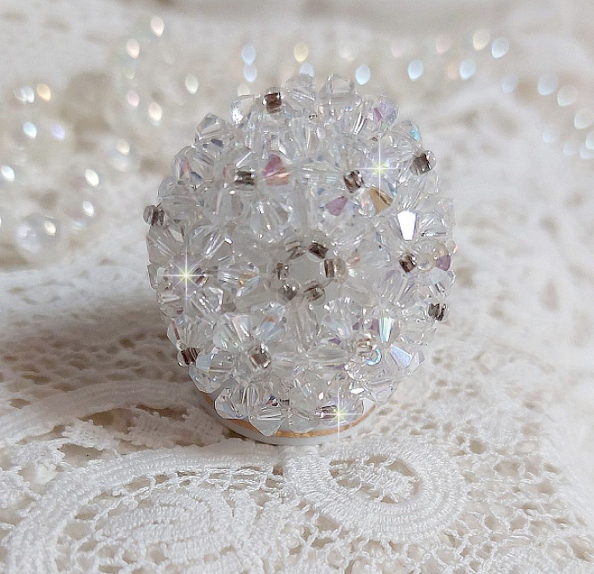  Bague Flocons mont&eacute;e avec des toupies en Cristal de Swarovski et des facettes en Verre de Boh&egrave;me o&ugrave; la couleur Blanche domine. Les perles s&rsquo;entrelacent avec les rocailles Argent&eacute;es comme des flocons 