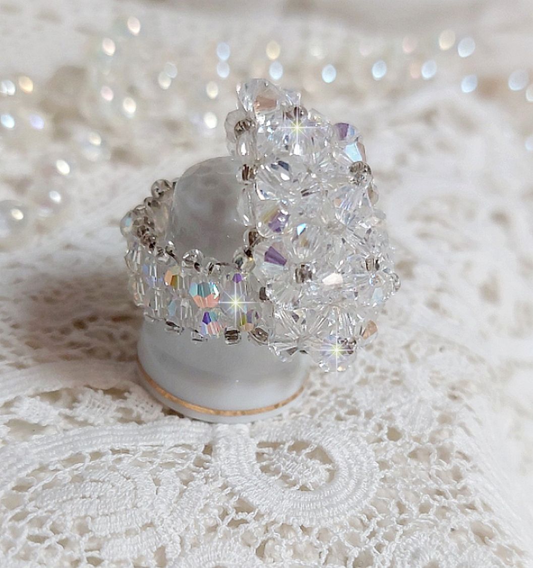  Bague Flocons mont&eacute;e avec des toupies en Cristal de Swarovski et des facettes en Verre de Boh&egrave;me o&ugrave; la couleur Blanche domine. Les perles s&rsquo;entrelacent avec les rocailles Argent&eacute;es comme des flocons 