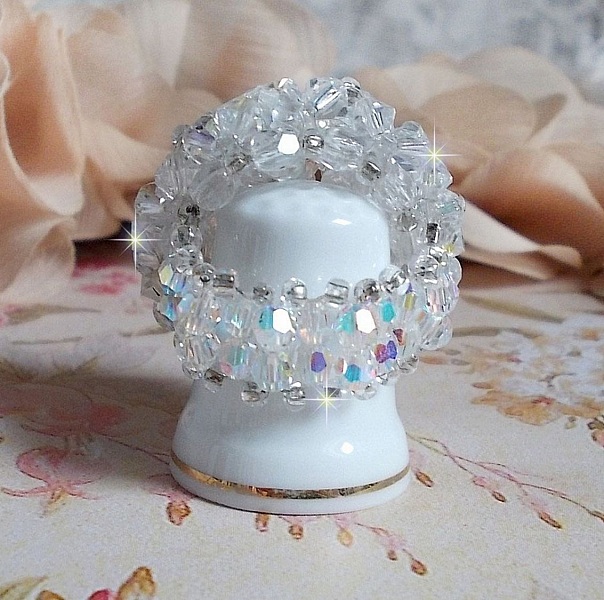  Bague Flocons mont&eacute;e avec des toupies en Cristal de Swarovski et des facettes en Verre de Boh&egrave;me o&ugrave; la couleur Blanche domine. Les perles s&rsquo;entrelacent avec les rocailles Argent&eacute;es comme des flocons 