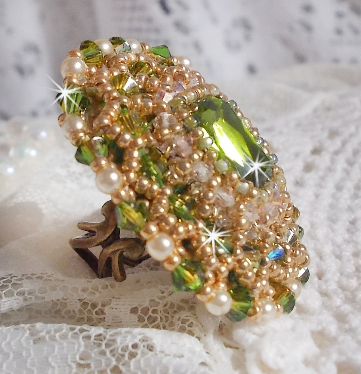 Bague Garden Party brod&eacute;e avec un cabochon en verre de boh&egrave;me des ann&eacute;es 1960 &agrave; laquelle s'ajoute des cristaux de Swarovski, perles nacr&eacute;es, chatons et rocailles Dor&eacute;es sur une bague Bronze