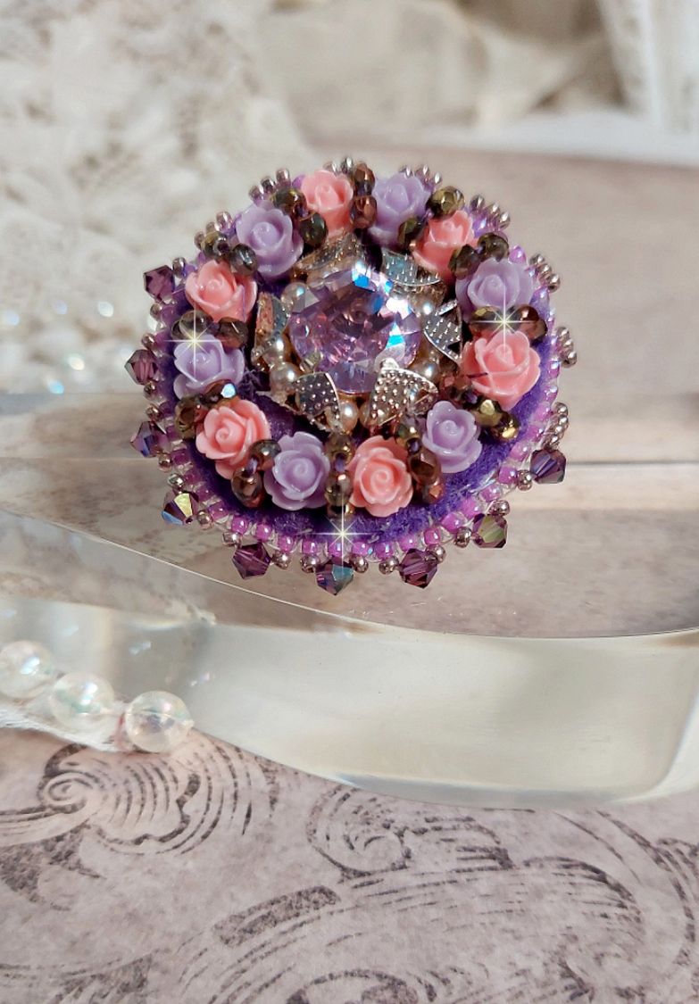 Bague Glace Purple brod&eacute;e avec un cabochon carr&eacute; Violet orn&eacute;e de cabochons roses en r&eacute;sine : Parme et Rose avec des toupies Am&eacute;thyste, facettes en Verre et rocailles. Mont&eacute;s sur une bague Dor&eacute;e