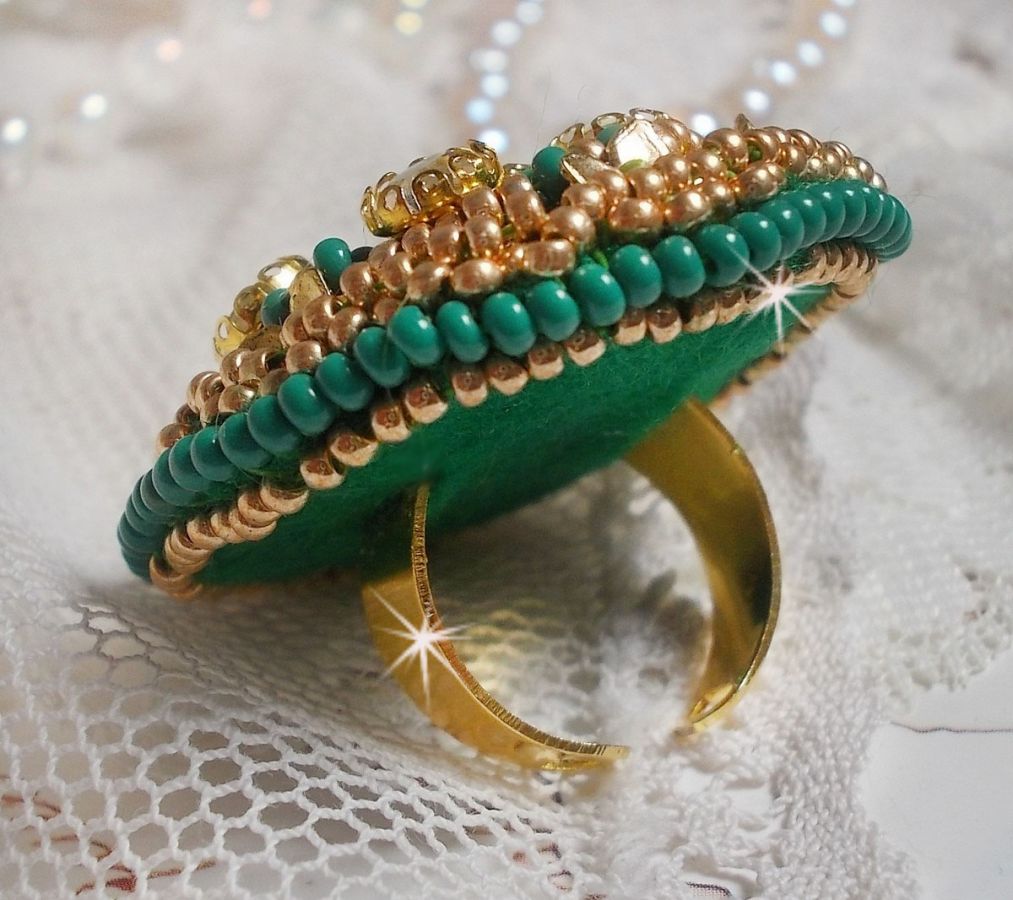 Bague Green Iris brod&eacute;e avec un cabochon Emeraude orn&eacute;e de chatons fleurs cristal sertis, rocailles Vert Opaque et Gold. Mont&eacute;s sur feutrine Verte et sur une bague plateau Dor&eacute;e, un style Contemporain