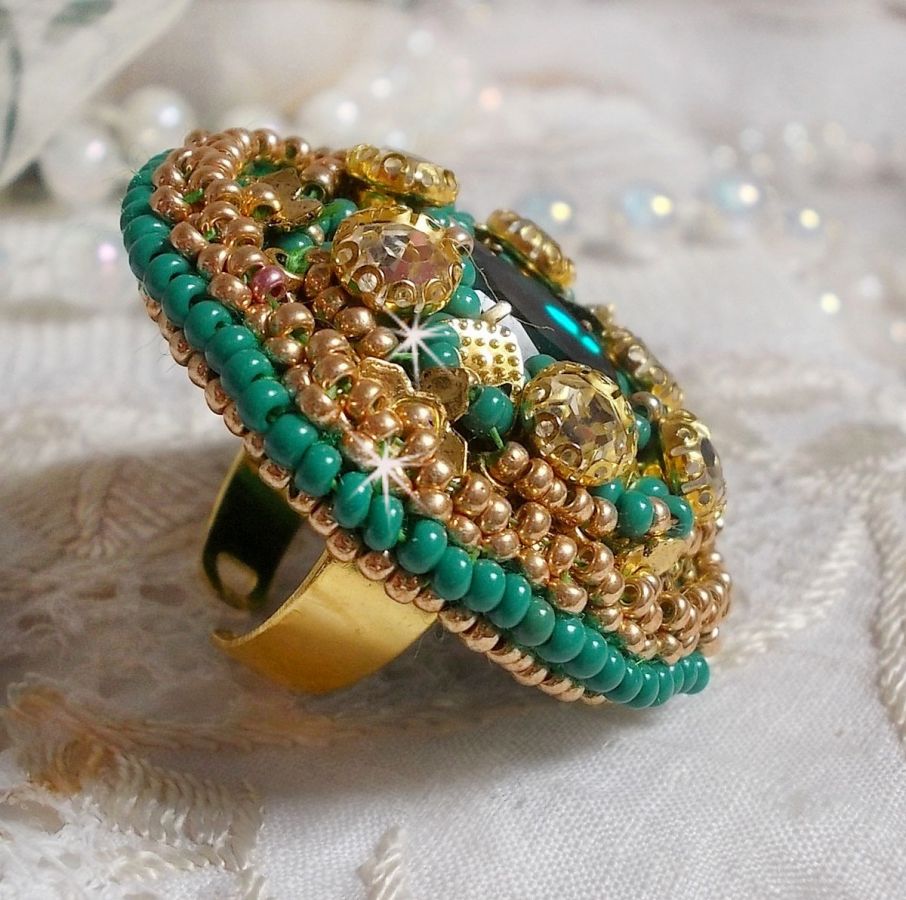Bague Green Iris brod&eacute;e avec un cabochon Emeraude orn&eacute;e de chatons fleurs cristal sertis, rocailles Vert Opaque et Gold. Mont&eacute;s sur feutrine Verte et sur une bague plateau Dor&eacute;e, un style Contemporain