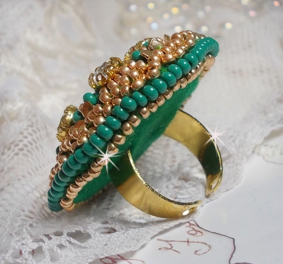 Bague Green Iris brod&eacute;e avec un cabochon Emeraude orn&eacute;e de chatons fleurs cristal sertis, rocailles Vert Opaque et Gold. Mont&eacute;s sur feutrine Verte et sur une bague plateau Dor&eacute;e, un style Contemporain