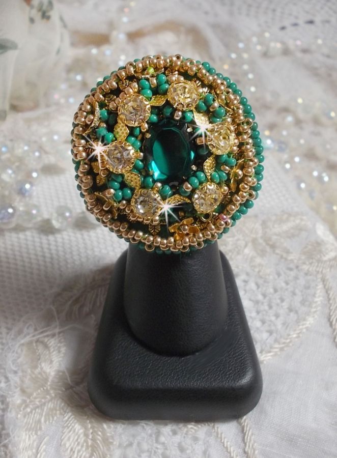 Bague Green Iris brod&eacute;e avec un cabochon Emeraude orn&eacute;e de chatons fleurs cristal sertis, rocailles Vert Opaque et Gold. Mont&eacute;s sur feutrine Verte et sur une bague plateau Dor&eacute;e, un style Contemporain