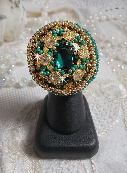 Bague Green Iris brod&eacute;e avec un cabochon Emeraude orn&eacute;e de chatons fleurs cristal sertis, rocailles Vert Opaque et Gold. Mont&eacute;s sur feutrine Verte et sur une bague plateau Dor&eacute;e, un style Contemporain