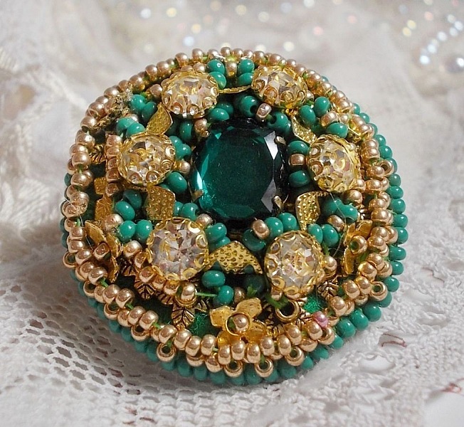 Bague Green Iris brod&eacute;e avec un cabochon Emeraude orn&eacute;e de chatons fleurs cristal sertis, rocailles Vert Opaque et Gold. Mont&eacute;s sur feutrine Verte et sur une bague plateau Dor&eacute;e, un style Contemporain
