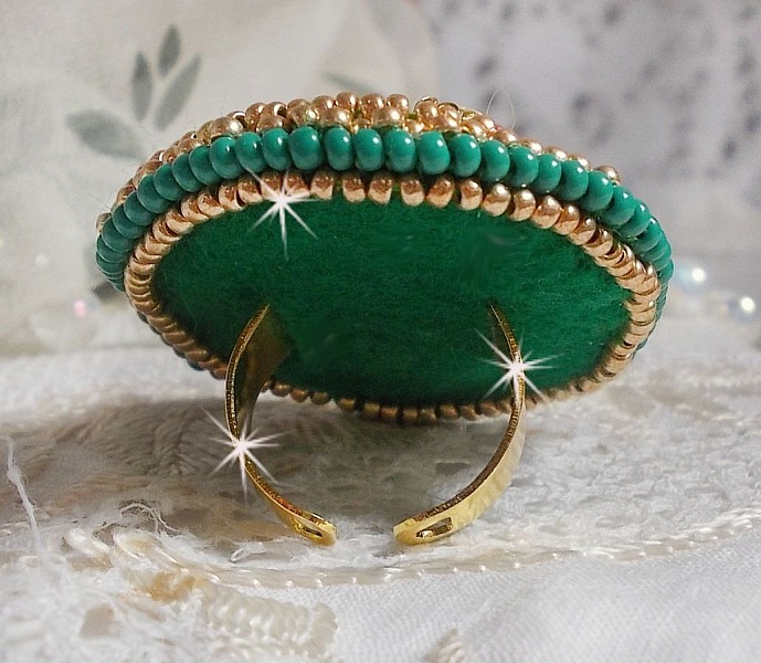 Bague Green Iris brod&eacute;e avec un cabochon Emeraude orn&eacute;e de chatons fleurs cristal sertis, rocailles Vert Opaque et Gold. Mont&eacute;s sur feutrine Verte et sur une bague plateau Dor&eacute;e, un style Contemporain