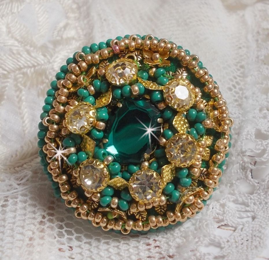 Bague Green Iris brod&eacute;e avec un cabochon Emeraude orn&eacute;e de chatons fleurs cristal sertis, rocailles Vert Opaque et Gold. Mont&eacute;s sur feutrine Verte et sur une bague plateau Dor&eacute;e, un style Contemporain