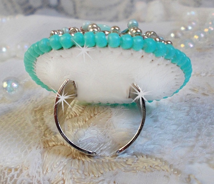 Bague Blue Flowers brod&eacute;e avec un cabochon en forme de rose en r&eacute;sine, cha&icirc;ne strass Cristal, toupies Jet de haute qualit&eacute; AB2X et farfalles ovales. Les couleurs sont : l&rsquo;Argent&eacute; et le Vert Menthe