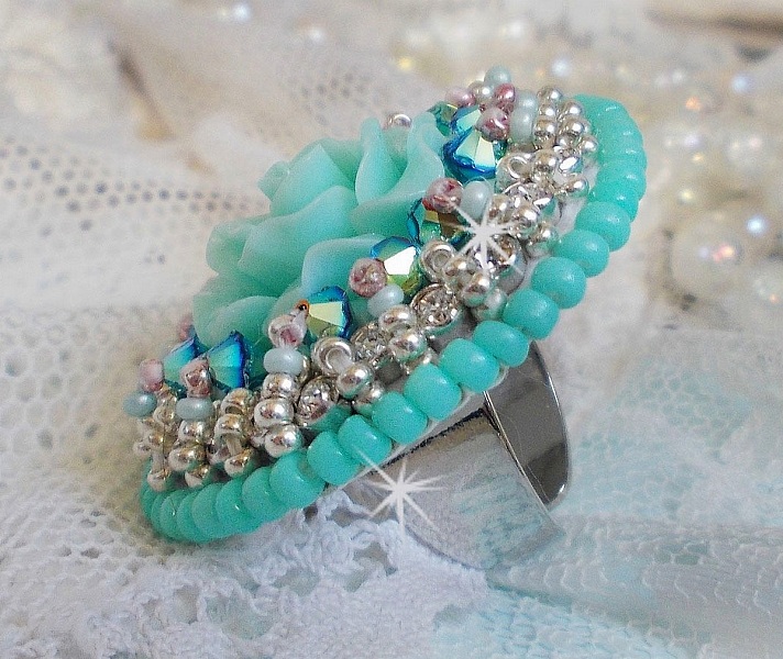 Bague Blue Flowers brod&eacute;e avec un cabochon en forme de rose en r&eacute;sine, cha&icirc;ne strass Cristal, toupies Jet de haute qualit&eacute; AB2X et farfalles ovales. Les couleurs sont : l&rsquo;Argent&eacute; et le Vert Menthe