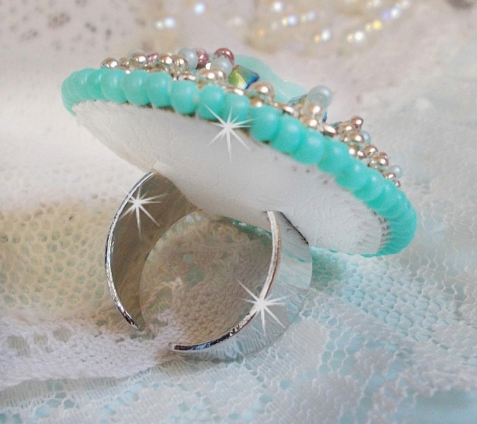 Bague Blue Flowers brod&eacute;e avec un cabochon en forme de rose en r&eacute;sine, cha&icirc;ne strass Cristal, toupies Jet de haute qualit&eacute; AB2X et farfalles ovales. Les couleurs sont : l&rsquo;Argent&eacute; et le Vert Menthe