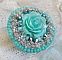 Bague Blue Flowers brod&eacute;e avec un cabochon en forme de rose en r&eacute;sine, cha&icirc;ne strass Cristal, toupies Jet de haute qualit&eacute; AB2X et farfalles ovales. Les couleurs sont : l&rsquo;Argent&eacute; et le Vert Menthe