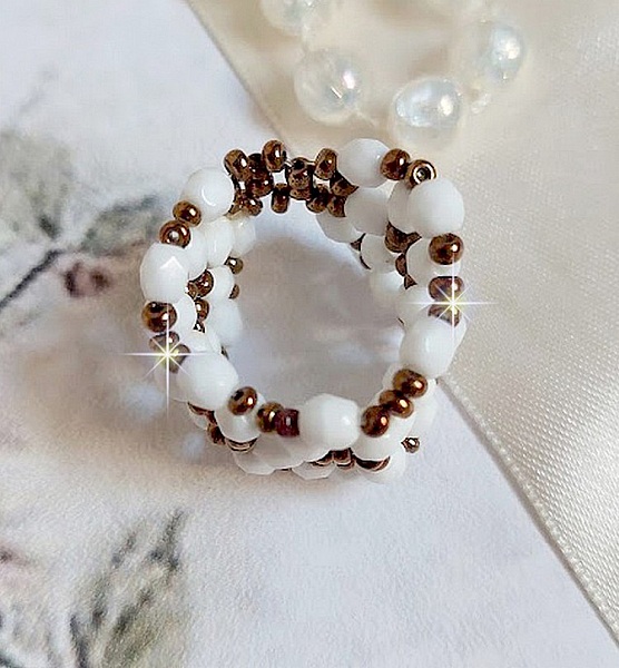 Bague Horizon mont&eacute;e avec des facettes en verre de boh&egrave;me et des rocailles en verre. Un beau duo de couleurs Blanc et Bronze pour un style contemporain