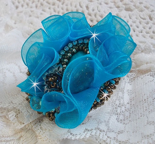 Bague artisanale brodée avec fleur en ruban bleu turquoise.