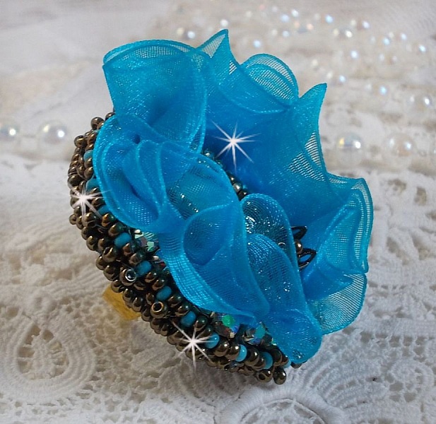 Bague artisanale bleue brodée avec perles et ruban turquoise.