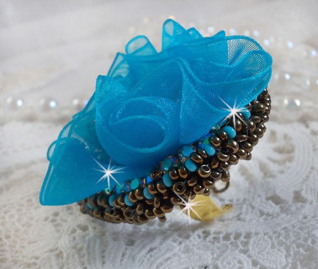 Bague artisanale bleue avec fleur en tissu et perles.