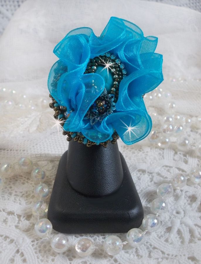 Bague artisanale bleue turquoise avec cabochon et détails perlés.