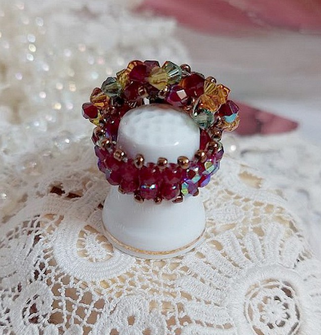 Bague Iroise mont&eacute;e avec des toupies et une navette en Cristal aux couleurs Rouge, Jaune, Topaz et Vert entrelac&eacute;es avec des rocailles Bronze sur des facettes en verre de boh&egrave;me Rouge