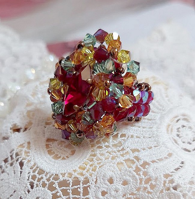 Bague Iroise mont&eacute;e avec des toupies et une navette en Cristal aux couleurs Rouge, Jaune, Topaz et Vert entrelac&eacute;es avec des rocailles Bronze sur des facettes en verre de boh&egrave;me Rouge
