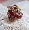 Bague Iroise mont&eacute;e avec des toupies et une navette en Cristal aux couleurs Rouge, Jaune, Topaz et Vert entrelac&eacute;es avec des rocailles Bronze sur des facettes en verre de boh&egrave;me Rouge