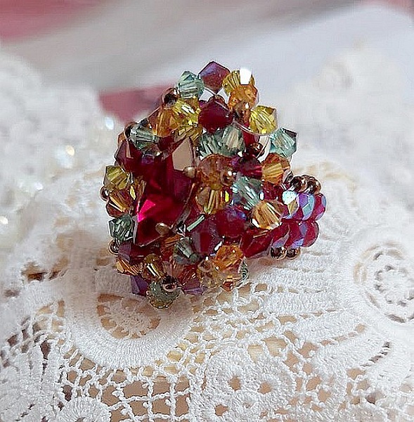 Bague Iroise mont&eacute;e avec des toupies et une navette en Cristal aux couleurs Rouge, Jaune, Topaz et Vert entrelac&eacute;es avec des rocailles Bronze sur des facettes en verre de boh&egrave;me Rouge