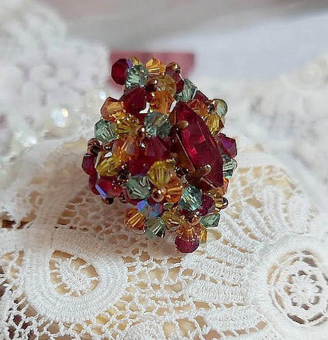 Bague Iroise mont&eacute;e avec des toupies et une navette en Cristal aux couleurs Rouge, Jaune, Topaz et Vert entrelac&eacute;es avec des rocailles Bronze sur des facettes en verre de boh&egrave;me Rouge