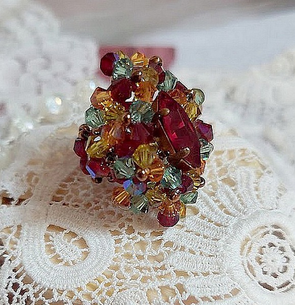 Bague Iroise mont&eacute;e avec des toupies et une navette en Cristal aux couleurs Rouge, Jaune, Topaz et Vert entrelac&eacute;es avec des rocailles Bronze sur des facettes en verre de boh&egrave;me Rouge