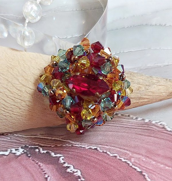Bague Iroise mont&eacute;e avec des toupies et une navette en Cristal aux couleurs Rouge, Jaune, Topaz et Vert entrelac&eacute;es avec des rocailles Bronze sur des facettes en verre de boh&egrave;me Rouge