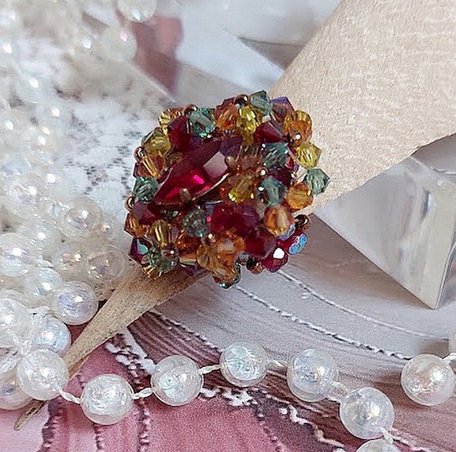 Bague Iroise mont&eacute;e avec des toupies et une navette en Cristal aux couleurs Rouge, Jaune, Topaz et Vert entrelac&eacute;es avec des rocailles Bronze sur des facettes en verre de boh&egrave;me Rouge