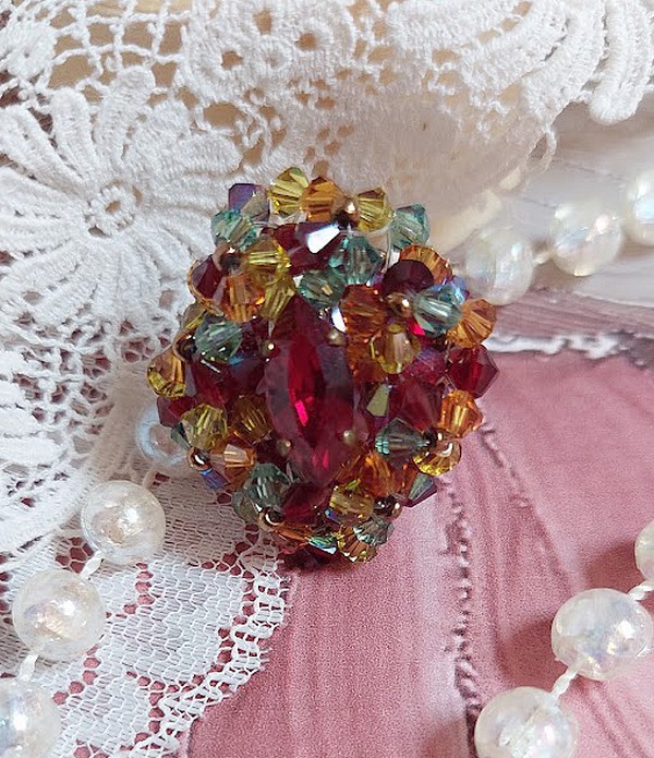 Bague Iroise mont&eacute;e avec des toupies et une navette en Cristal aux couleurs Rouge, Jaune, Topaz et Vert entrelac&eacute;es avec des rocailles Bronze sur des facettes en verre de boh&egrave;me Rouge