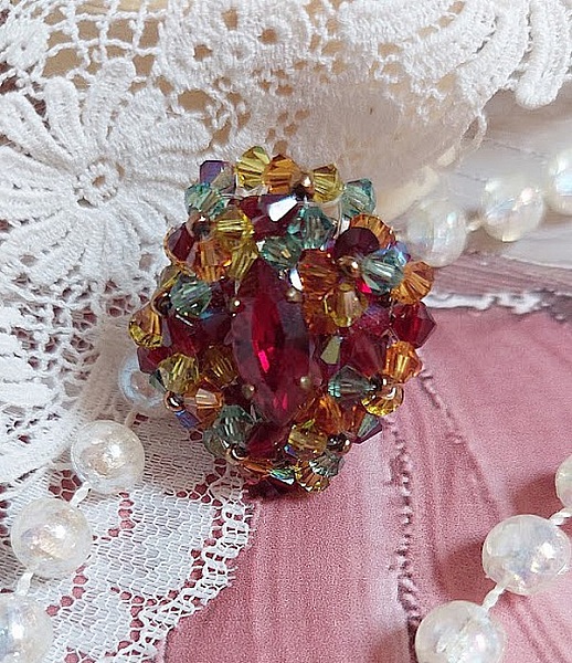 Bague Iroise mont&eacute;e avec des toupies et une navette en Cristal aux couleurs Rouge, Jaune, Topaz et Vert entrelac&eacute;es avec des rocailles Bronze sur des facettes en verre de boh&egrave;me Rouge