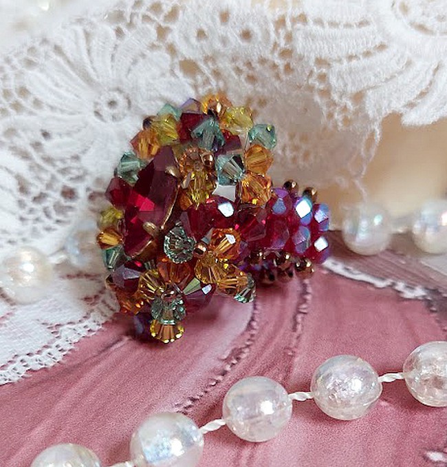Bague Iroise mont&eacute;e avec des toupies et une navette en Cristal aux couleurs Rouge, Jaune, Topaz et Vert entrelac&eacute;es avec des rocailles Bronze sur des facettes en verre de boh&egrave;me Rouge