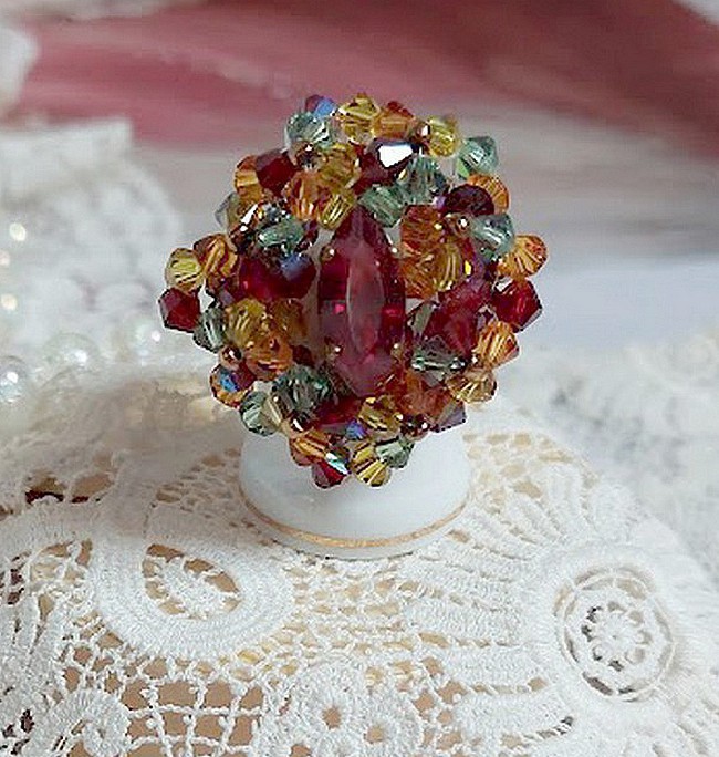 Bague Iroise mont&eacute;e avec des toupies et une navette en Cristal aux couleurs Rouge, Jaune, Topaz et Vert entrelac&eacute;es avec des rocailles Bronze sur des facettes en verre de boh&egrave;me Rouge